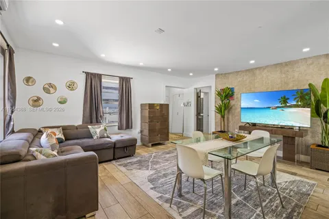 a living room with furniture kitchen view and a large window