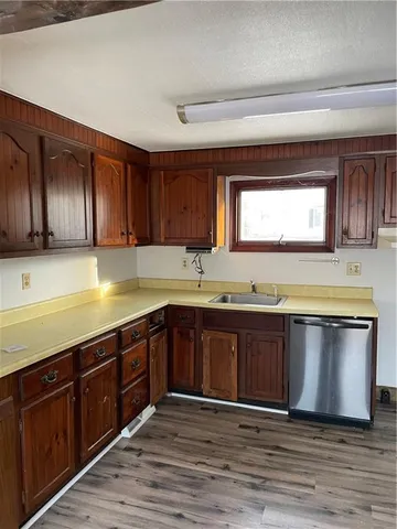 a view of a kitchen counter space a sink wooden floor and a window