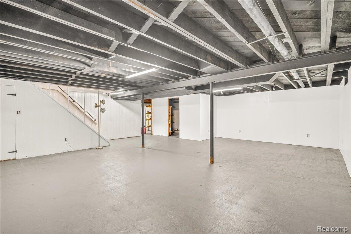 11802 Columbia Street Redford, MI 48239 - Photo 24 of 39 Expansive finished lower level featuring finished concrete flooring, drywall, and a painted exposed ceiling with overhead lighting.