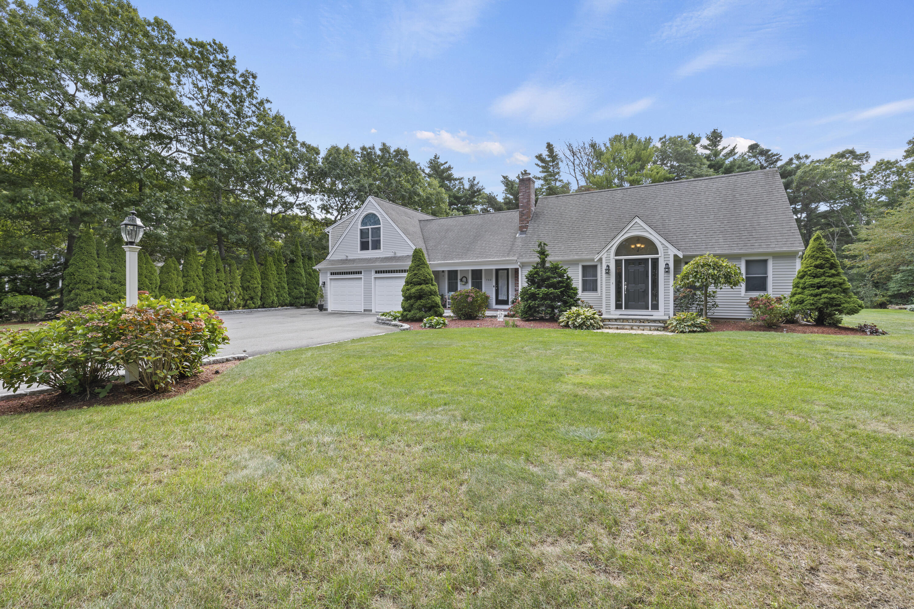 a front view of a house with a garden and plants