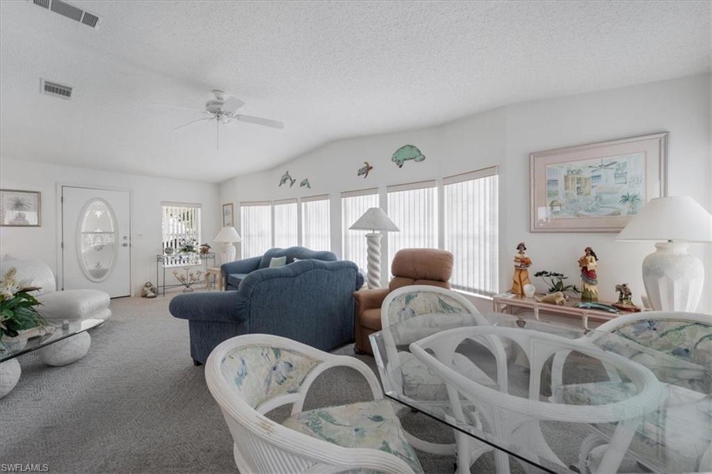 256 Riverwood Road Naples, FL 34114 - Photo 7 of 30 a living room with furniture and a chandelier