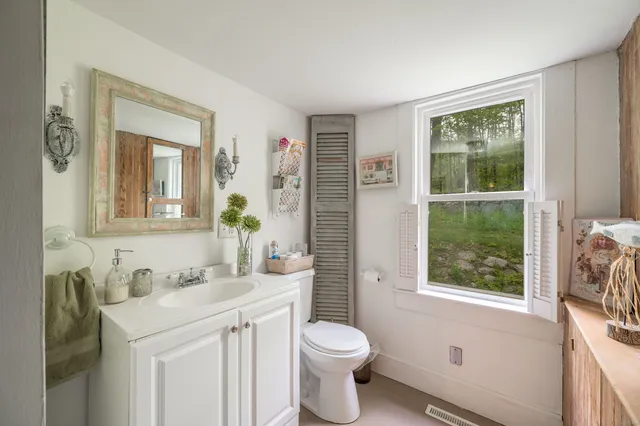 a bathroom with a sink vanity mirror and toilet