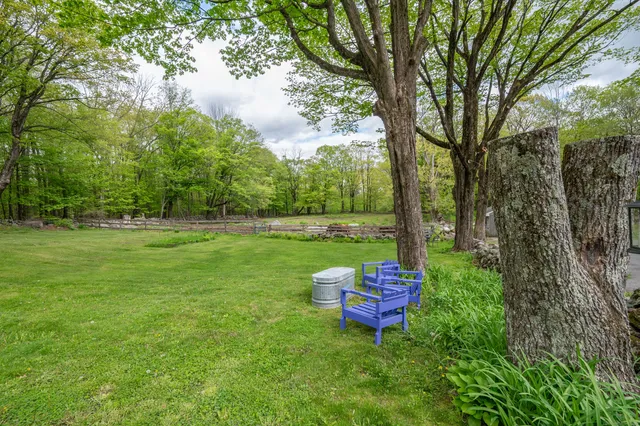 a backyard of a house with lots of green space table and chairs