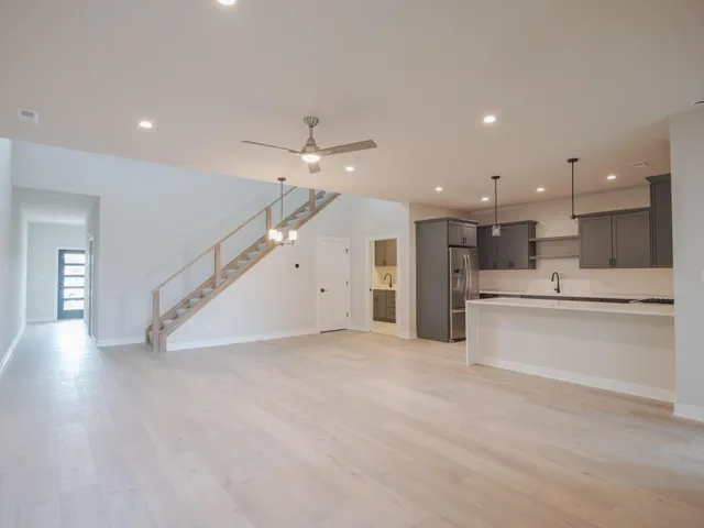 a view of a kitchen with kitchen island a sink stainless steel appliances and cabinets