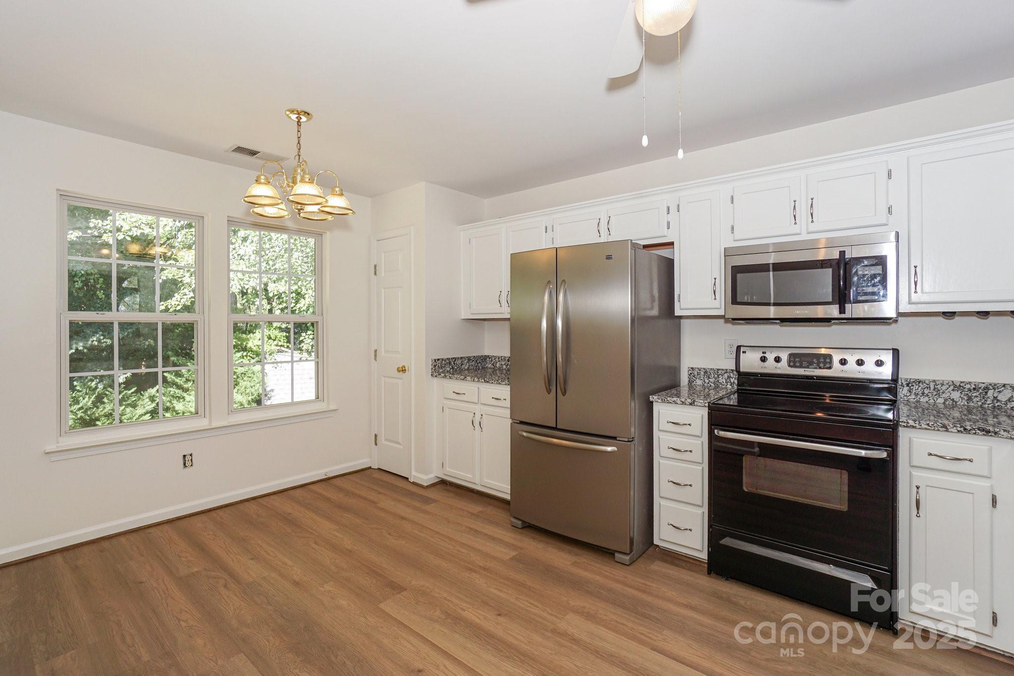 2485 Acadia Court Kannapolis, NC 28083 - Photo 11 of 34 a kitchen with stainless steel appliances a refrigerator stove and microwave