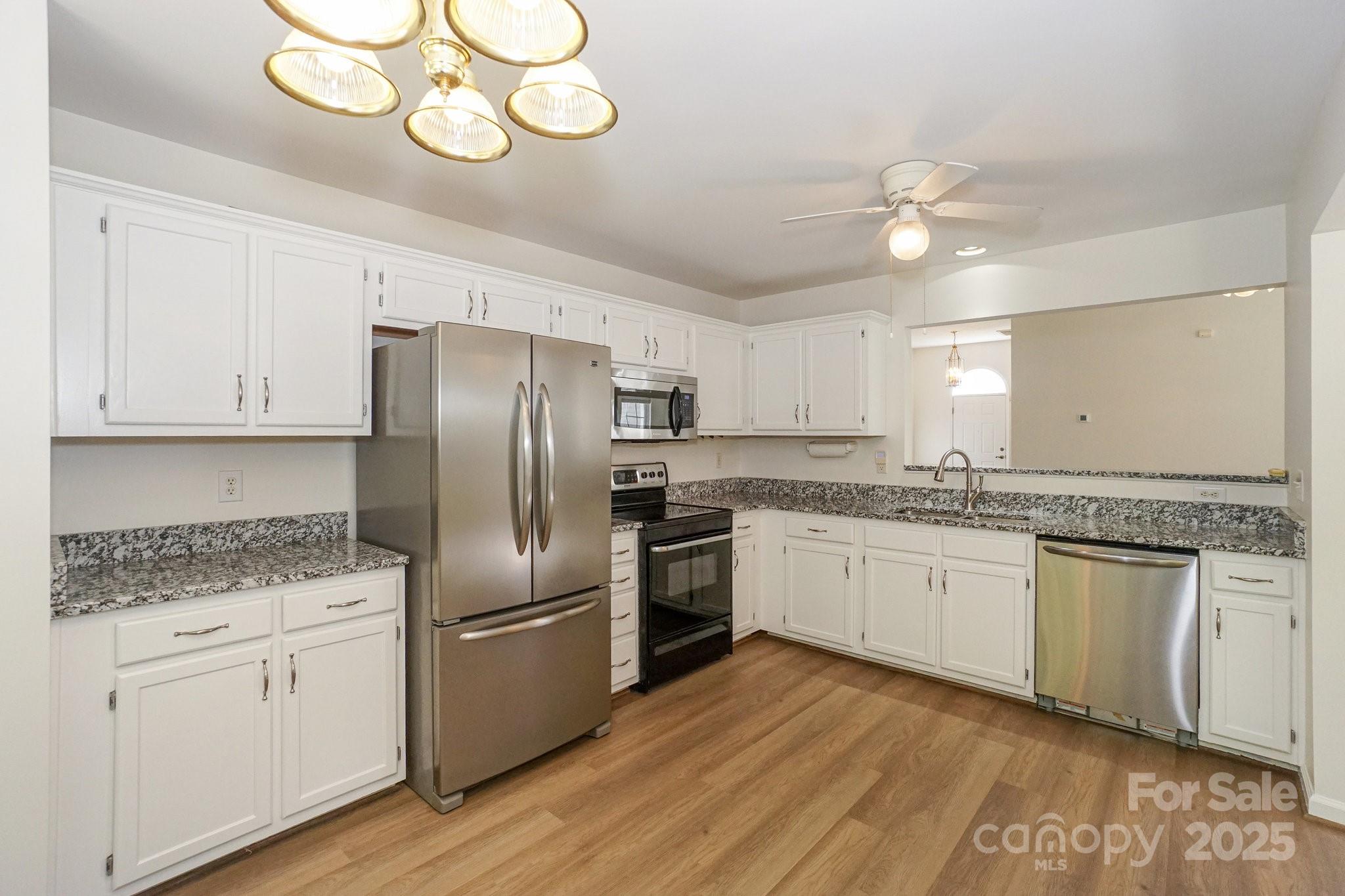 2485 Acadia Court Kannapolis, NC 28083 - Photo 12 of 34 a kitchen with stainless steel appliances granite countertop a sink a stove a refrigerator and island with wooden floor