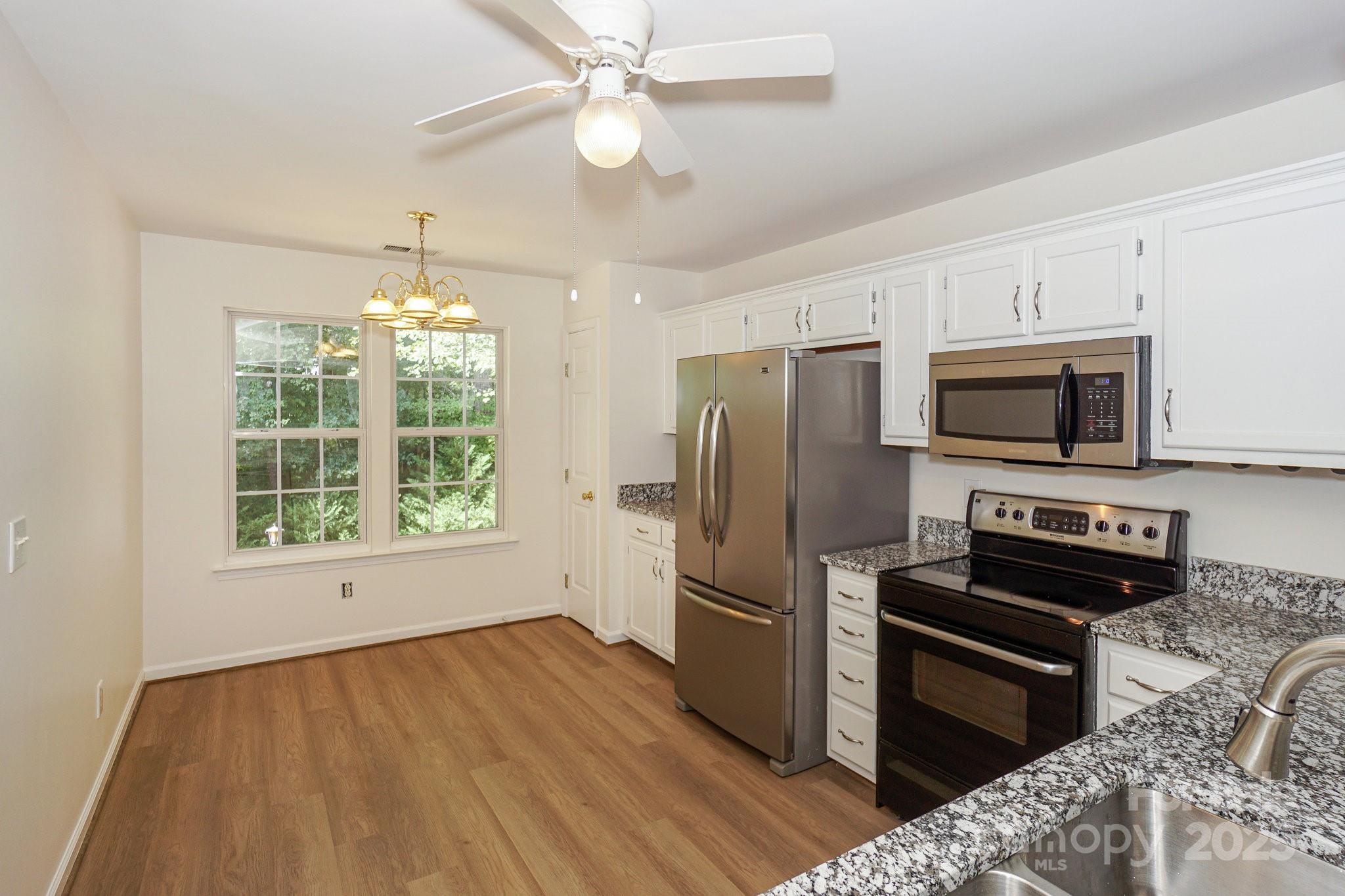 2485 Acadia Court Kannapolis, NC 28083 - Photo 14 of 34 a kitchen with stainless steel appliances a stove a refrigerator cabinets and a wooden floor
