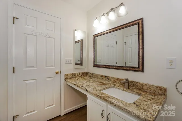 a bathroom with a granite countertop sink and a mirror