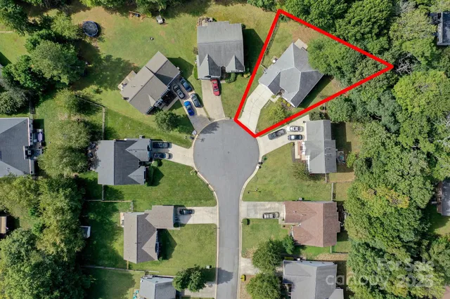an aerial view of a house with a yard and outdoor seating