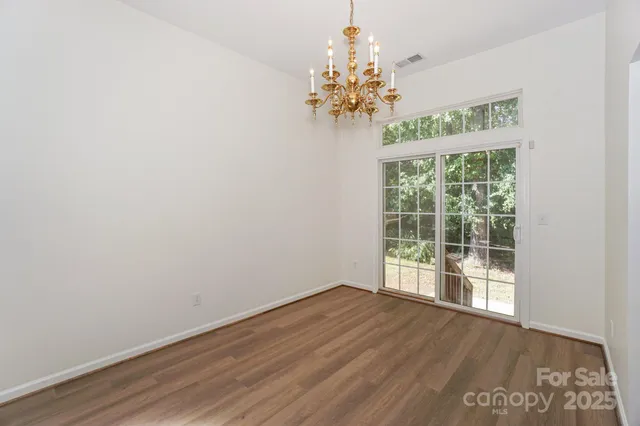 a view of a room with wooden floor and chandelier