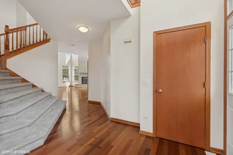 a view of a hallway with wooden floor and staircase
