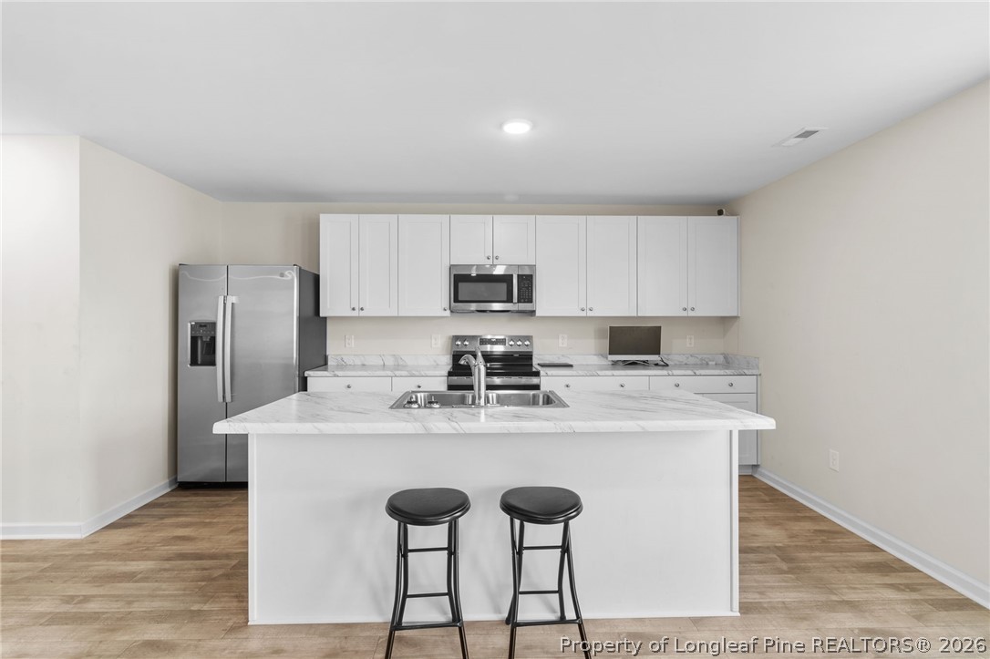 33 Pointer Way Parkton, NC 28371 - Photo 13 of 44 a kitchen with stainless steel appliances granite countertop a sink a stove a refrigerator and island with wooden cabinets