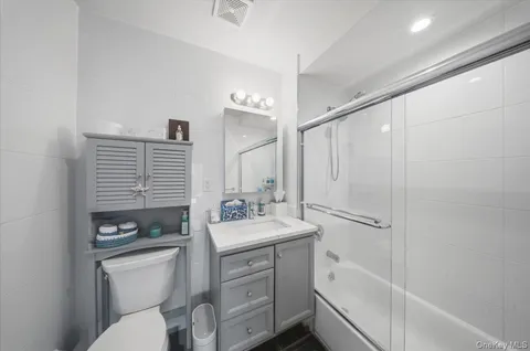 a bathroom with a sink a toilet a mirror and shower