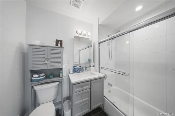 a bathroom with a sink a toilet a mirror and shower