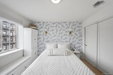 a bedroom with a bed and a window with exposed radiator