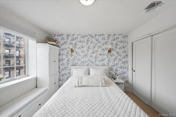 a bedroom with a bed and a window with exposed radiator