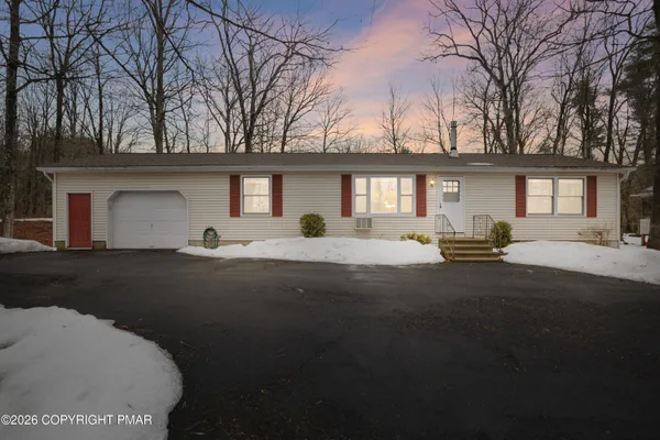 a view of a house with a backyard and a tree