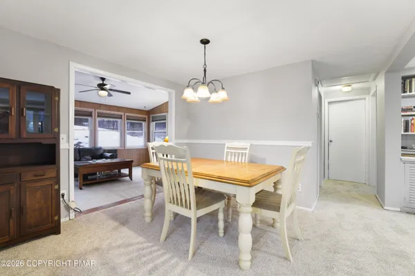 a view of a dining room with furniture and a chandelier