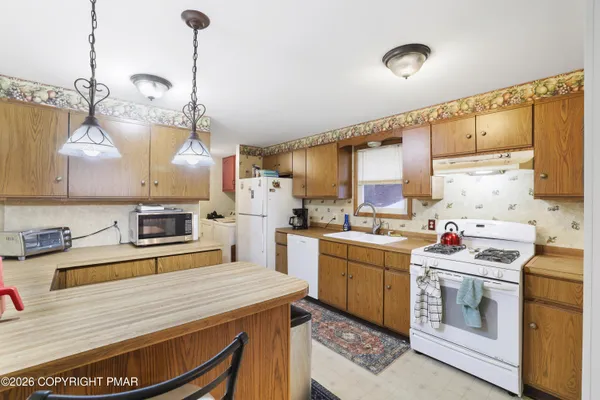 a kitchen that has a lot of cabinets in it and wooden floors