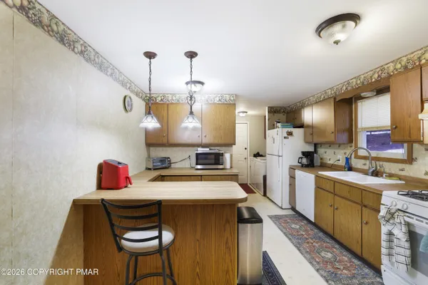 a kitchen with a stove a refrigerator and a fireplace