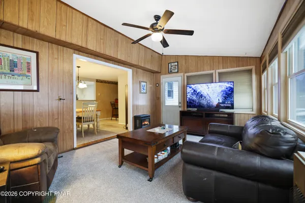 a living room with furniture a flat screen tv and a window