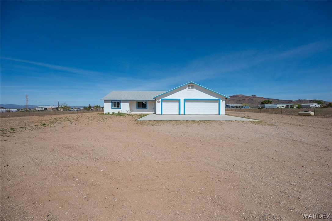 3411 West Carmichael Road Golden Valley, AZ 86413 - Photo 65 of 97 Ranch-style house with driveway, a mountain view, an attached garage, and stucco siding