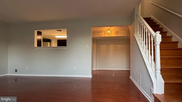 a view of a hallway with wooden floor and windows