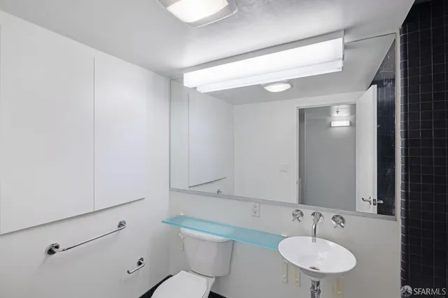 a bathroom with a sink toilet and a mirror