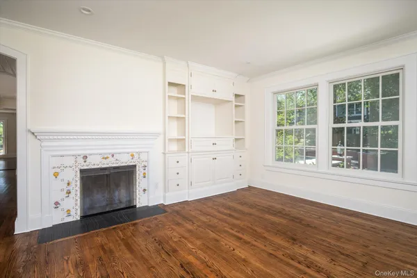 an empty room with windows and fireplace