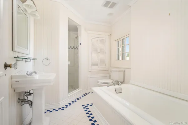 a bathroom with a tub sink and mirror