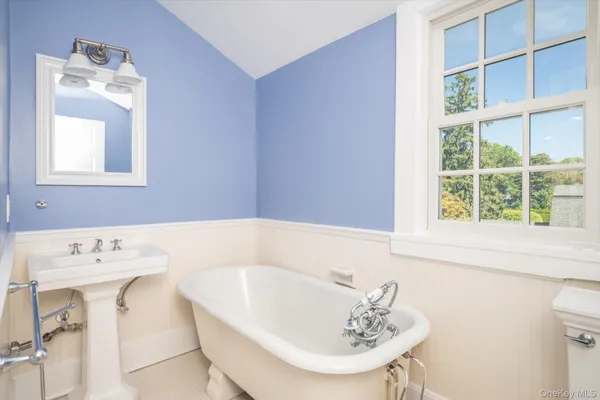 a bathroom with a bathtub a sink and a window