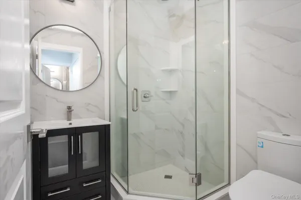a bathroom with a toilet a sink and mirror