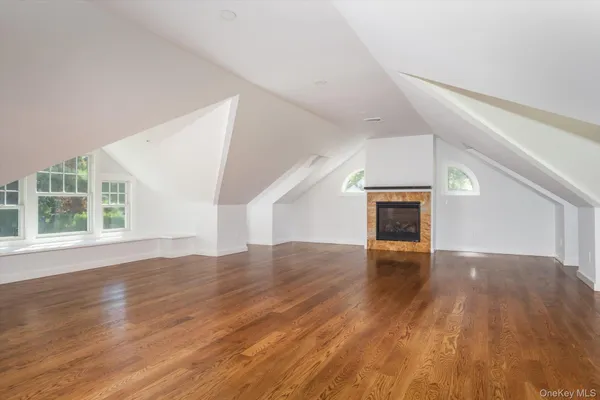 a view of empty room with wooden floor and fireplace