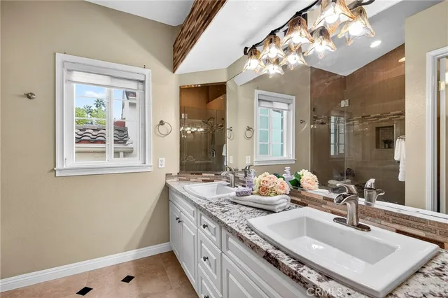 a bathroom with a sink double vanity granite and a mirror