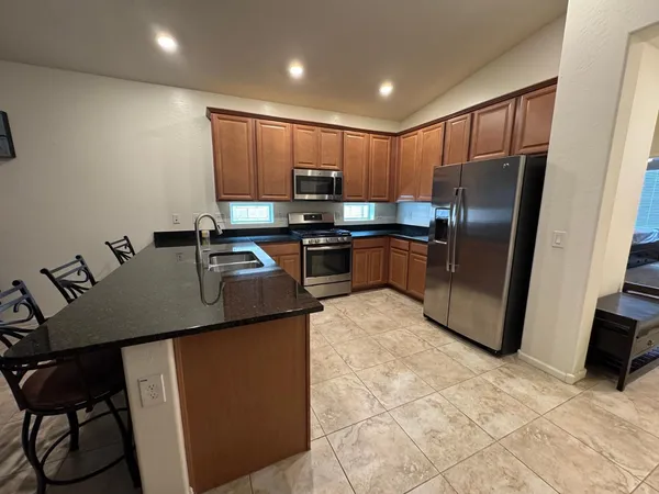 a kitchen with kitchen island a counter top space appliances and a sink