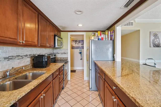a kitchen with stainless steel appliances granite countertop a sink a stove and a wooden floors