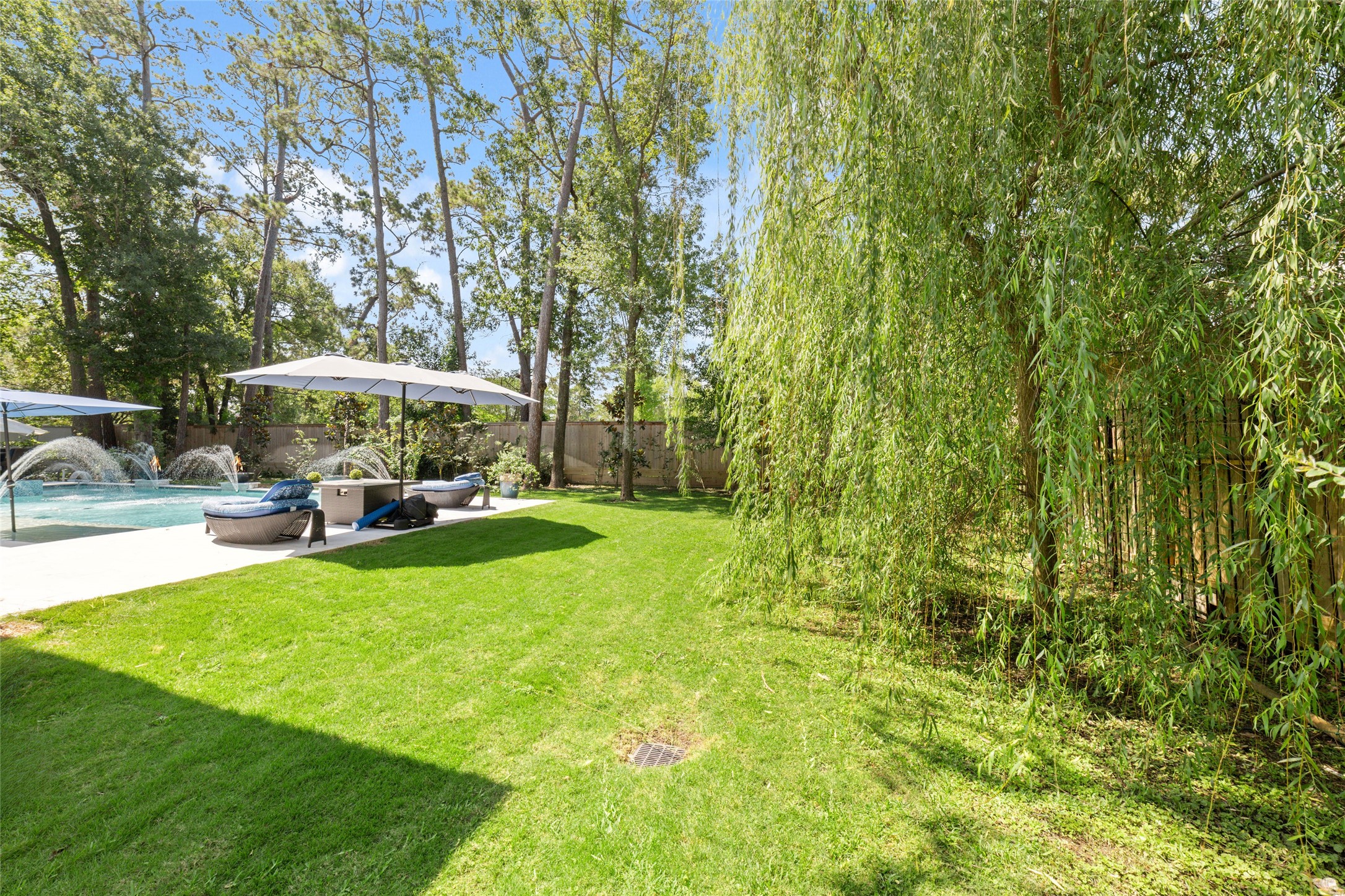 335 Voss Road Houston, TX 77024 - Photo 13 of 45 a view of a swimming pool with lawn chairs under an umbrella