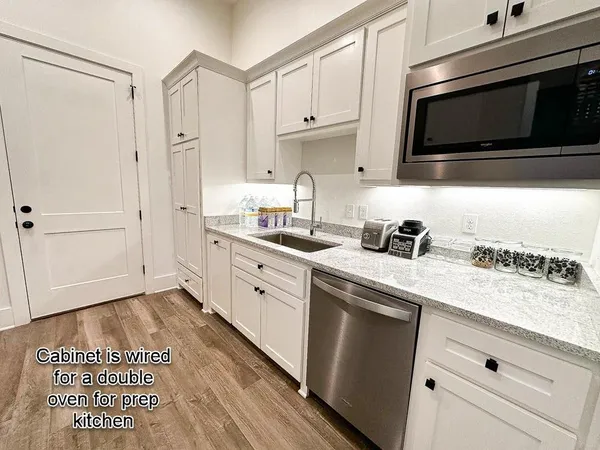 a kitchen with stainless steel appliances white cabinets and a stove top oven