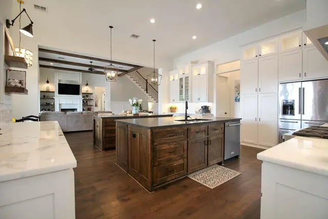 a kitchen with kitchen island granite countertop a sink a counter top space stainless steel appliances and cabinets