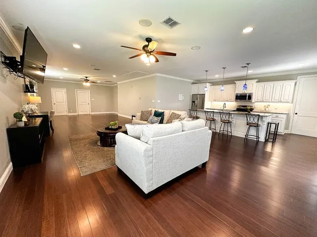 a kitchen with stainless steel appliances a dining table chairs microwave and sink