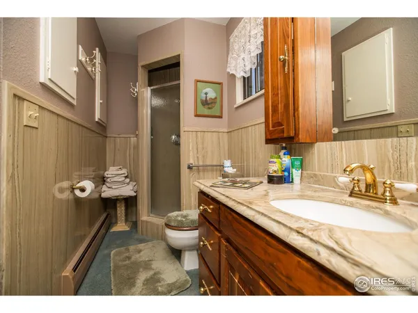 a bathroom with a granite countertop sink mirror vanity and toilet