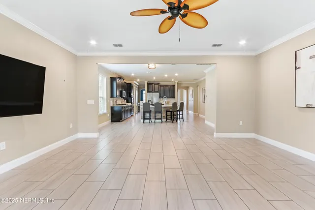 an empty room with a window and a chandelier fan