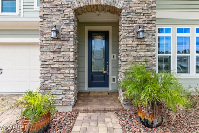 a front view of a house with potted plants