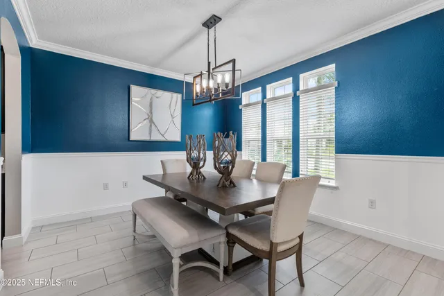 a view of a dining room with furniture and a chandelier