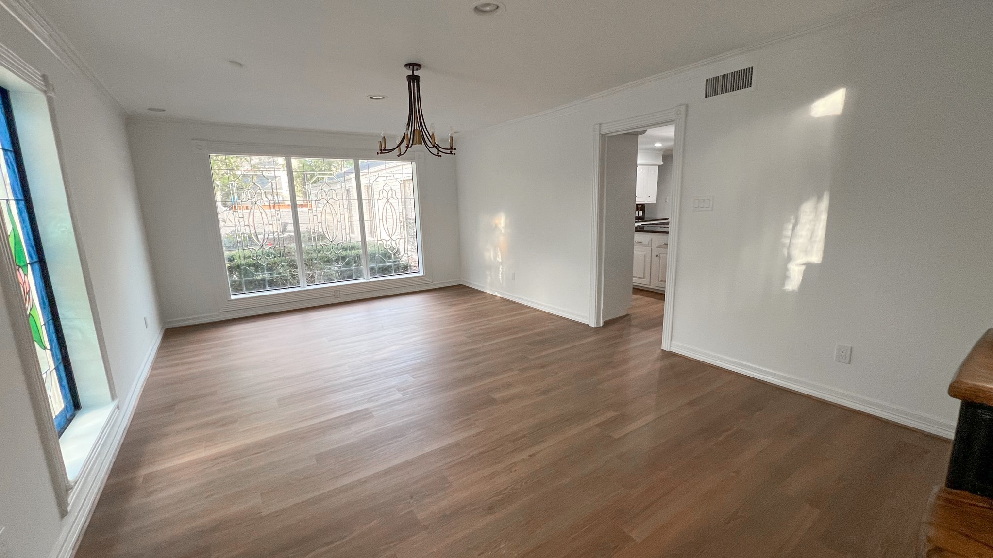 372 Robbins Drive Houston, TX 77024 - Photo 7 of 18 Gather in the formal dining room, where a midcentury-style chandelier anchors the space, complemented by large ornate windows that flood the room with abundant natural light, creating an inviting atmosphere for meals and gatherings.