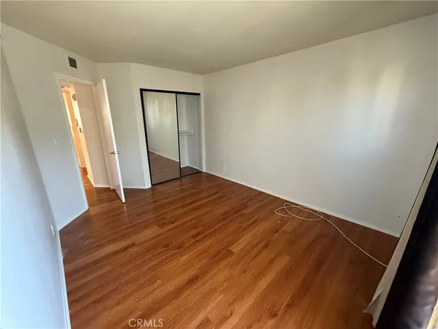an empty room with wooden floor and closet