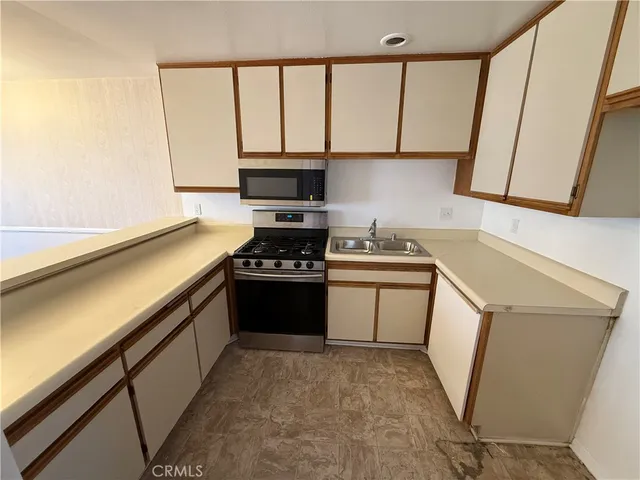a kitchen with a sink a stove and cabinets
