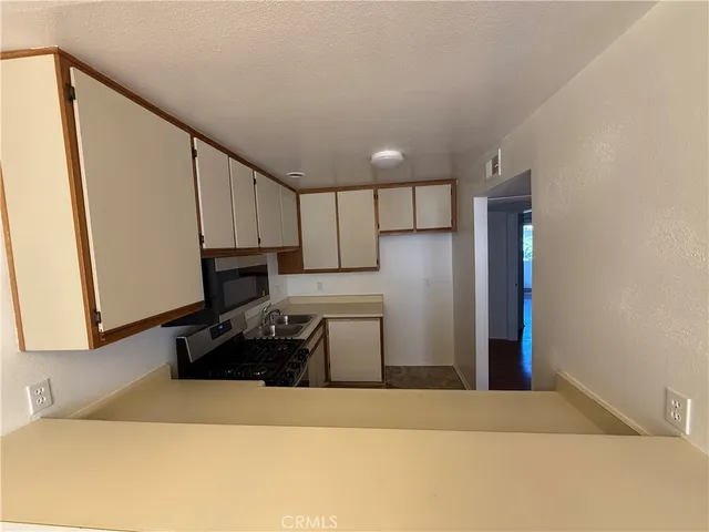 a kitchen with a refrigerator and a stove top oven