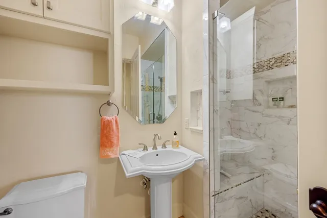 a bathroom with a sink a toilet and shower