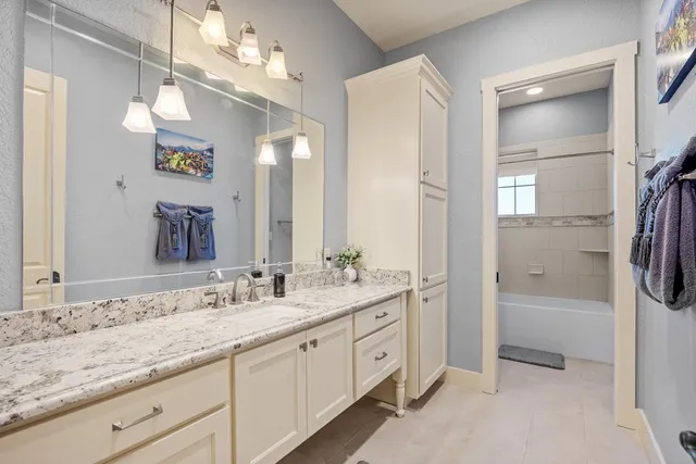 a spacious bathroom with a granite countertop sink mirror and a
